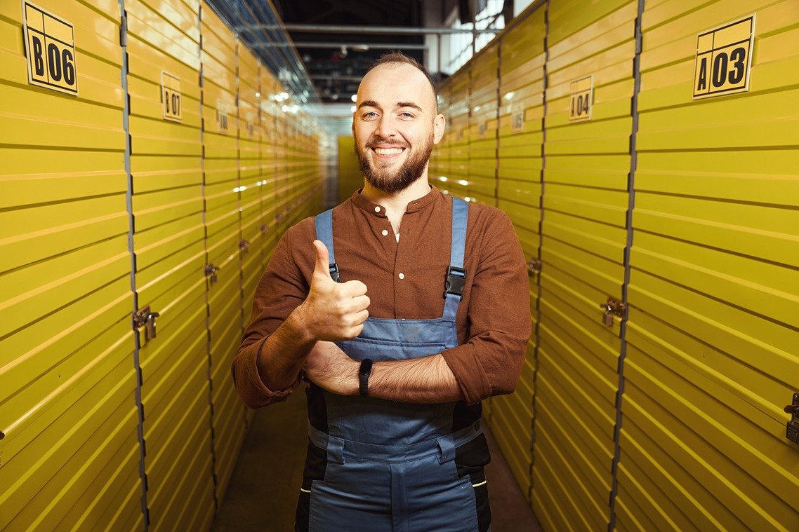 happy young male showing a thumbs up in the storag LT3YPH8
